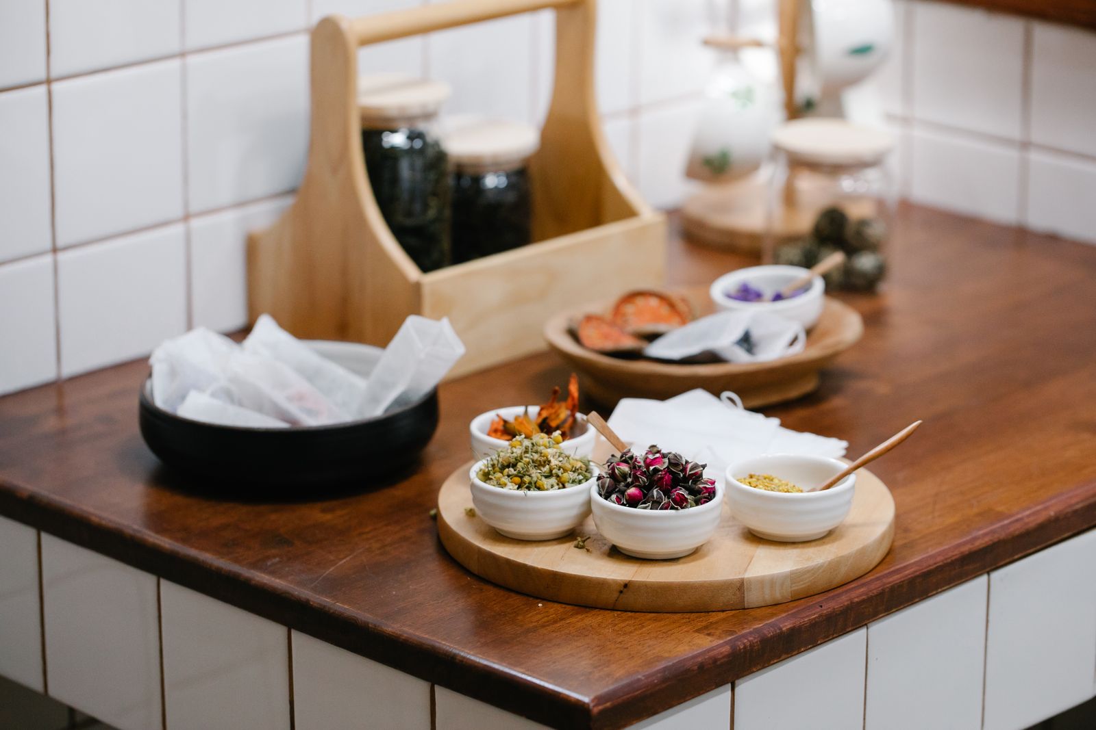 An assortment of dried herbs and spices in bowls on a table